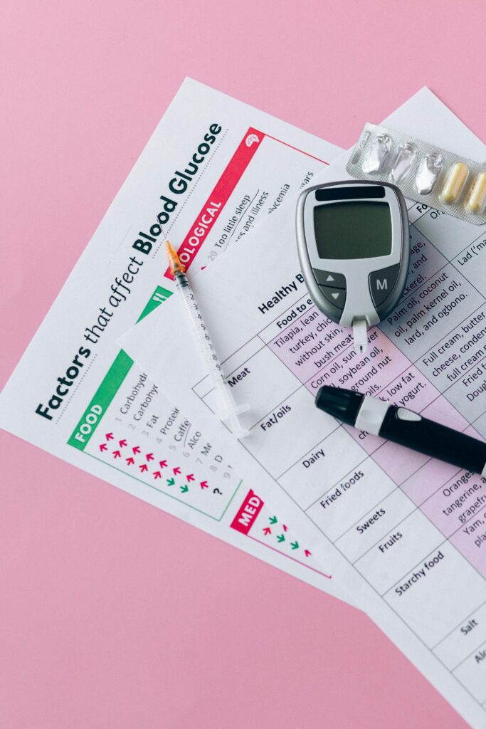 pexels-photo-8965150-8965150 Glucometer, syringe, and health charts for diabetes management on pink background.